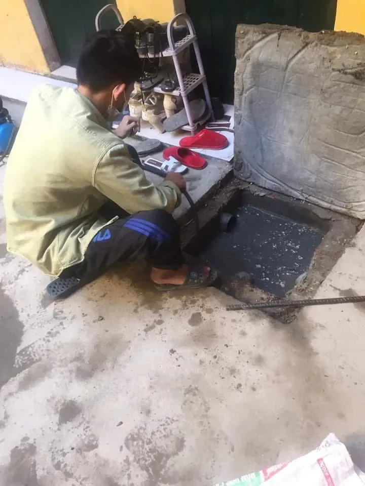 Người thợ tại GreenFix24h đang thực hiện thông tắc hầm cầu bằn máy lò xo