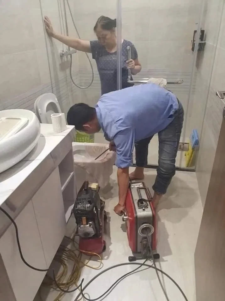 Dịch Vụ Thông Thoát Sàn Nhà Tắm - Hết Tắc, Hết Mùi Trong 30 Phút 3 Thợ đang tiến hành thông nước thoát sàn cho khách hàng